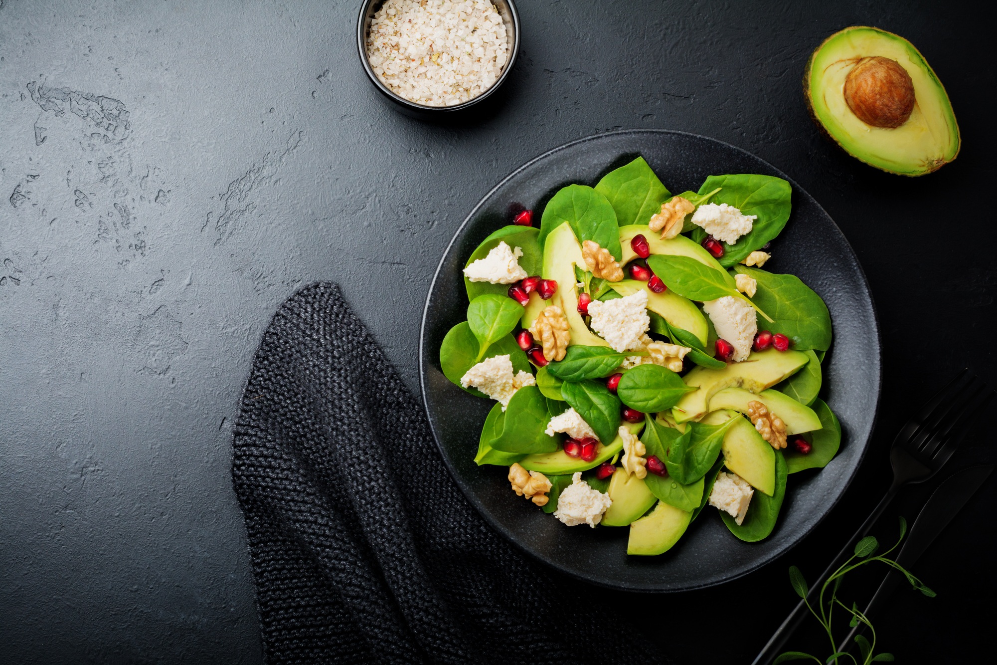 Fresh useful vegetarian wholesome avocado, spinach, pomegranate seeds, walnut, saffron, pepper and r